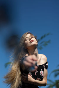 Portrait of woman standing against sky