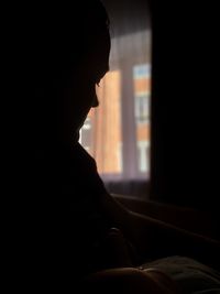 Side view of silhouette woman at home