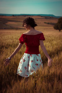 Rear view of woman with umbrella on field