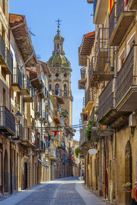 Alley amidst buildings against clear sky