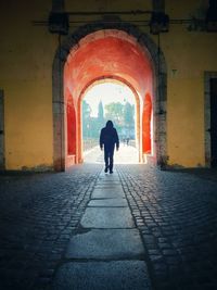 Rear view of man walking in tunnel