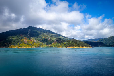 Scenic view of sea and mountains against sky