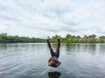 Man surfing in lake against sky