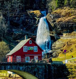 View of waterfall in forest against buildings