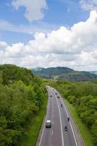 Road amidst green landscape against sky