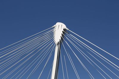 Low angle view of suspension bridge against clear blue sky