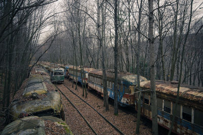 High angle view of abandoned trains amidst bare trees