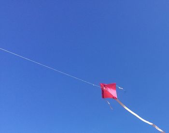 Low angle view of flag against clear blue sky