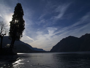 Scenic view of sea and silhouette mountains against sky