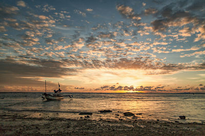 Silhouette boats in sea against sky during sunset