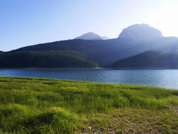 Scenic view of lake and mountains against clear sky