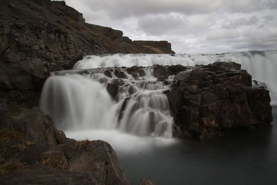 Scenic view of waterfall against rocks