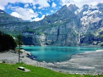 Scenic view of lake by mountains against sky