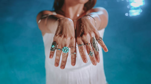 Low section of woman holding gift against blue background