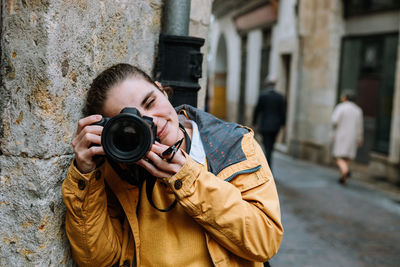 Woman photographing with camera on street