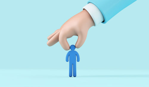 Close-up of hand holding eyeglasses against white background