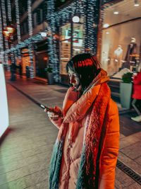 Side view of woman using mobile phone at night