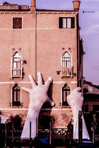 Low angle view of clothes hanging on building against sky