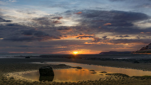 Scenic view of beach against sky during sunset