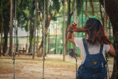 Rear view of woman standing in playground