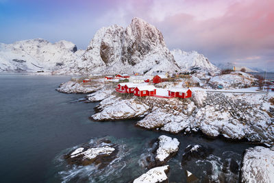 Scenic view of houses on snowcapped mountains against sky