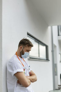 Tired male doctor in front of building