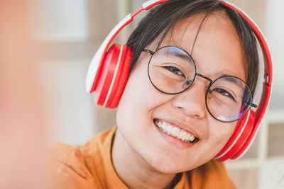 Close-up portrait of smiling girl with headphones