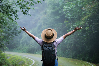 Rear view of man standing against trees