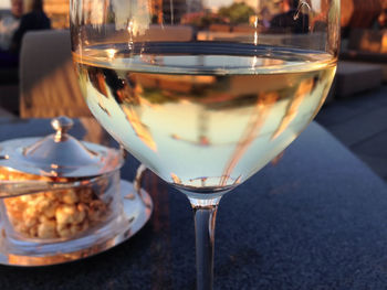 Reflections of buildings in wineglass on table at restaurant