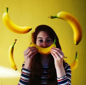 Portrait of beautiful young woman with bananas