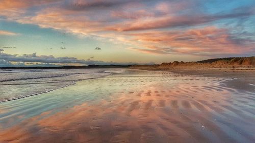 Scenic view of beach against sky during sunset