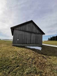 Barn on field against sky