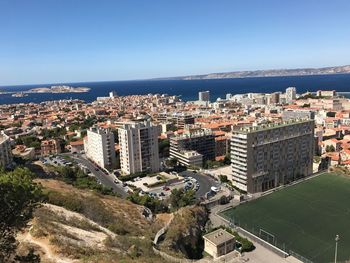 High angle view of town by sea against clear sky