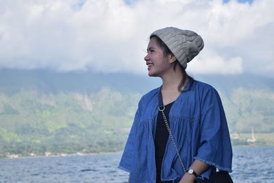 Young woman looking away againts lake toba