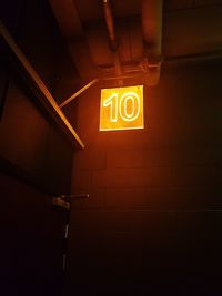 Low angle view of illuminated text on wall at night