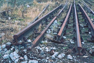 Abandoned railroad track amidst trees in field