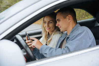 Portrait of smiling young woman sitting in car