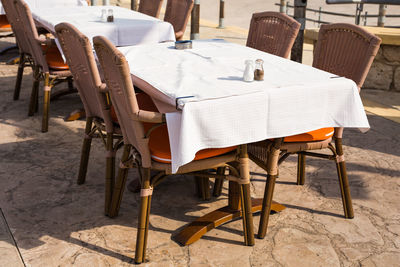 Empty chairs and tables against building