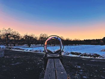 Scenic view of snowy field against clear sky during sunset