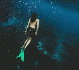 Low angle view of young woman swimming underwater