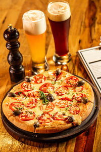High angle view of pizza and glass on table in restaurant