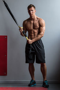 Portrait of shirtless muscular man exercising in gym