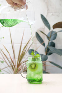 Close-up of hand holding drink on table