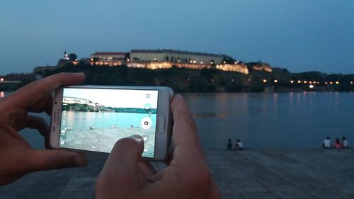 Close-up of hand using mobile phone at night