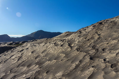 Scenic view of desert against clear blue sky