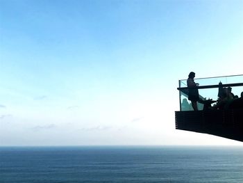 Man looking at sea against blue sky