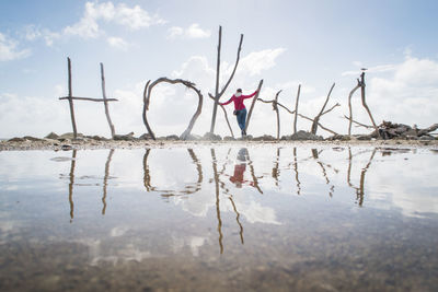 Woman standing with hokitika text at beach