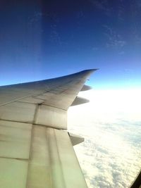 Cropped image of airplane flying over clouds