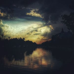 Scenic view of river against cloudy sky at sunset