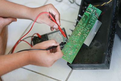 Cropped hands repairing motherboard